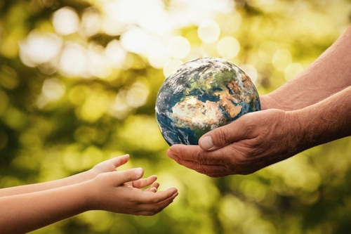 globe being passed down from an elder to a child