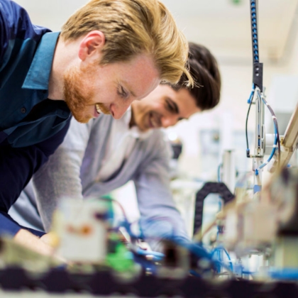 Two Kiwa engineers working together on a machine in a lab