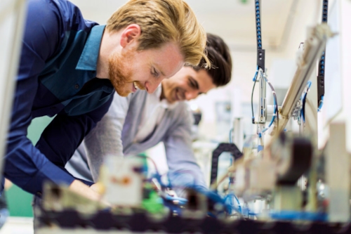 Two Kiwa engineers working together on a machine in a lab