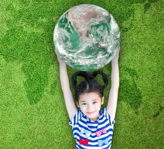 A little girl holding a world globe.