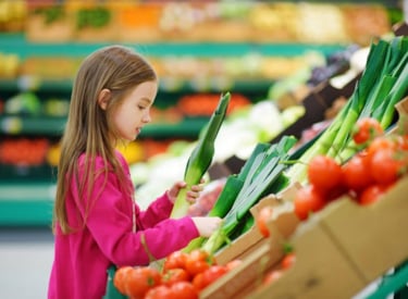 Kind op de groenteafdeling in de supermarkt