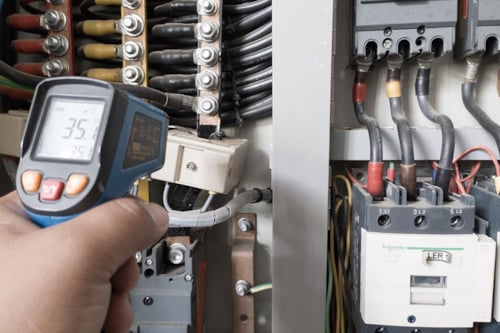 En elektriker använder en termopistol för att analysera underledningar och komponenter för att ta reda på överströmsbelastningar och avvikelser för en elanläggning.