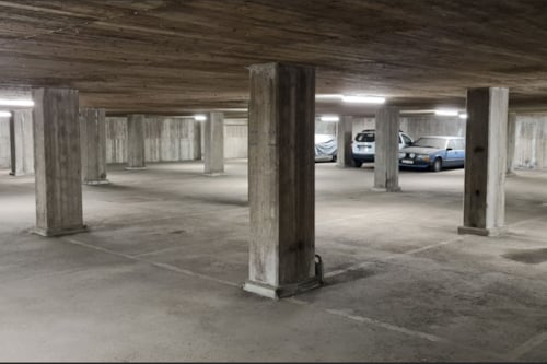 Garage med betonggolv och betongpelare.